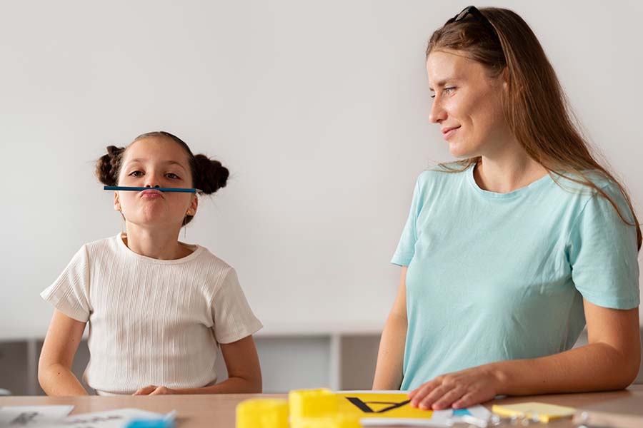 Menina com TDAH distraída apoiando um lápis nos lábios durante uma consulta psicológica. Representação do papel do psicólogo no TDAH.
