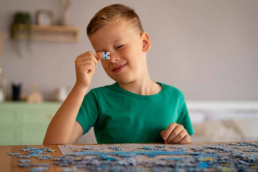 Criança com autismo brincando com um quebra-cabeça.
